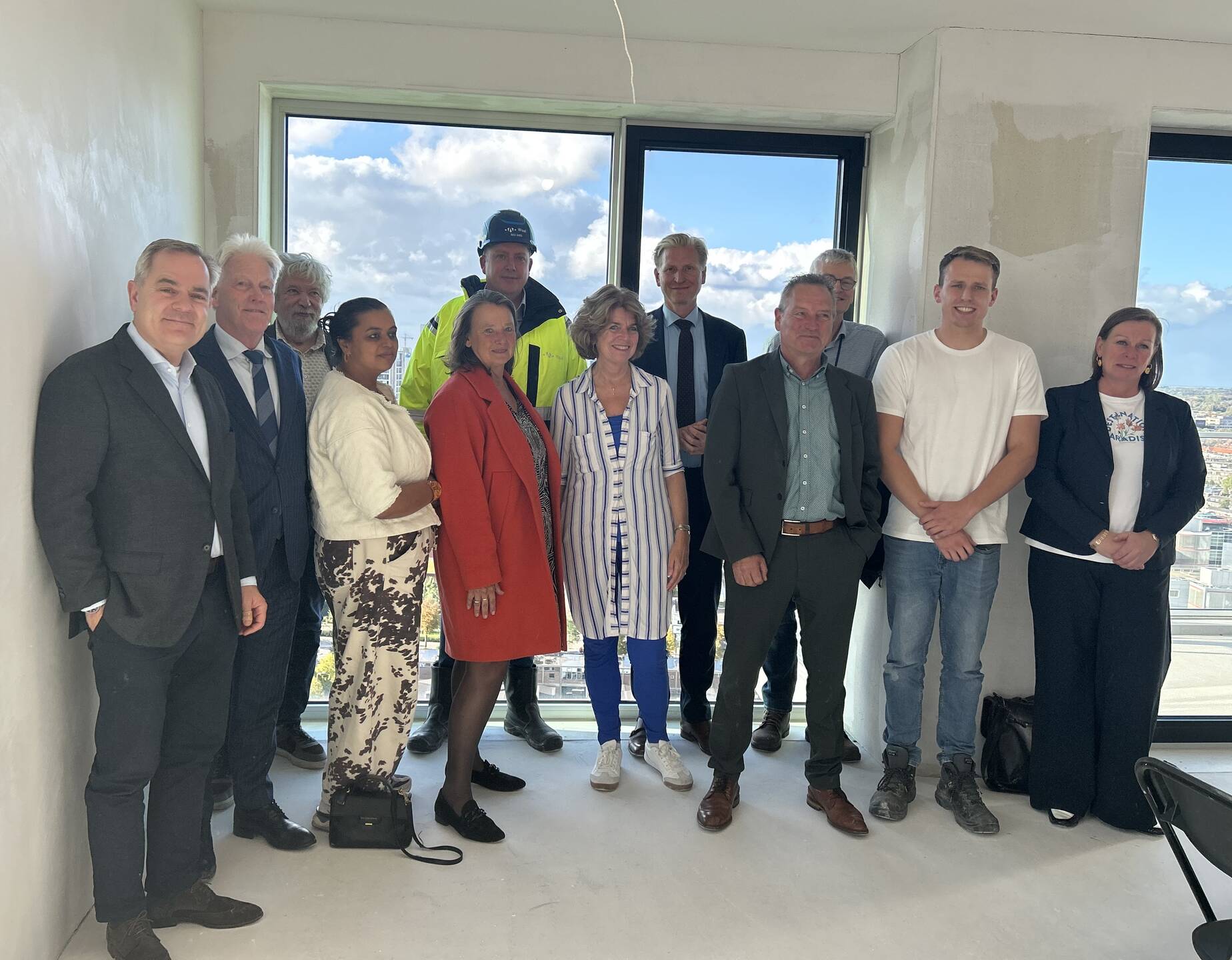 Commissieleden poseren met medewerkers van de Arbeidsinspectie en bouwbedrijf Waal